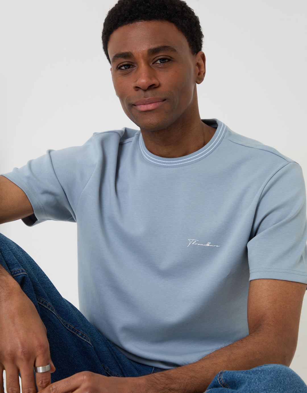 Threadbare Cotton Crew Neck Script T-Shirt in Blue - front view, seated